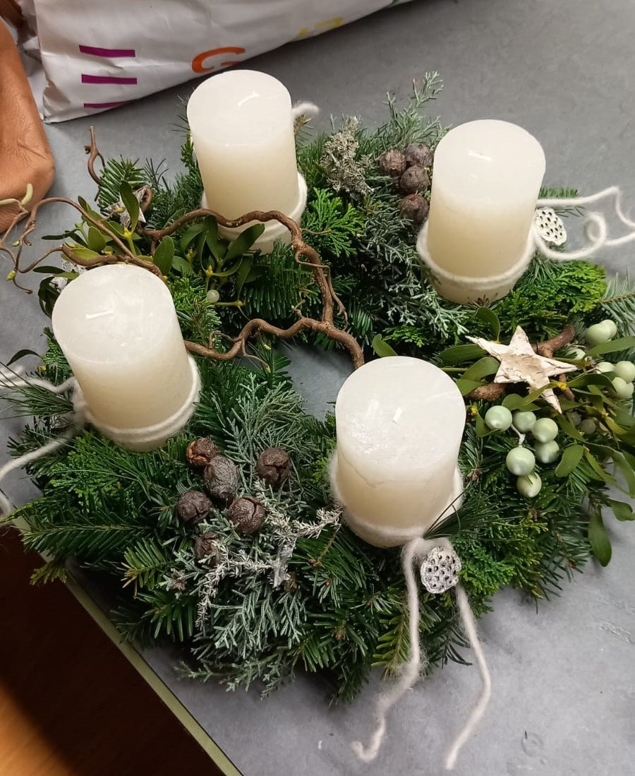Adventkranz mit weißen Kerzen schön dekoriert